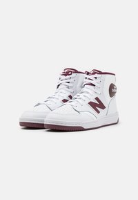Pair of white high-top New Balance sneakers with maroon accents and laces, displayed against a plain background.