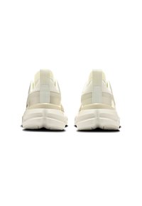 Scarpe sportive di colore beige chiaro con una tomaia in mesh traspirante, collo imbottito e suola bianca spessa con un motivo testurizzato.