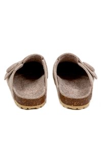 Sabots gris à dos ouvert, à bout rond et semelle en liège brun texturé. Présente un bouton décoratif sur le côté.