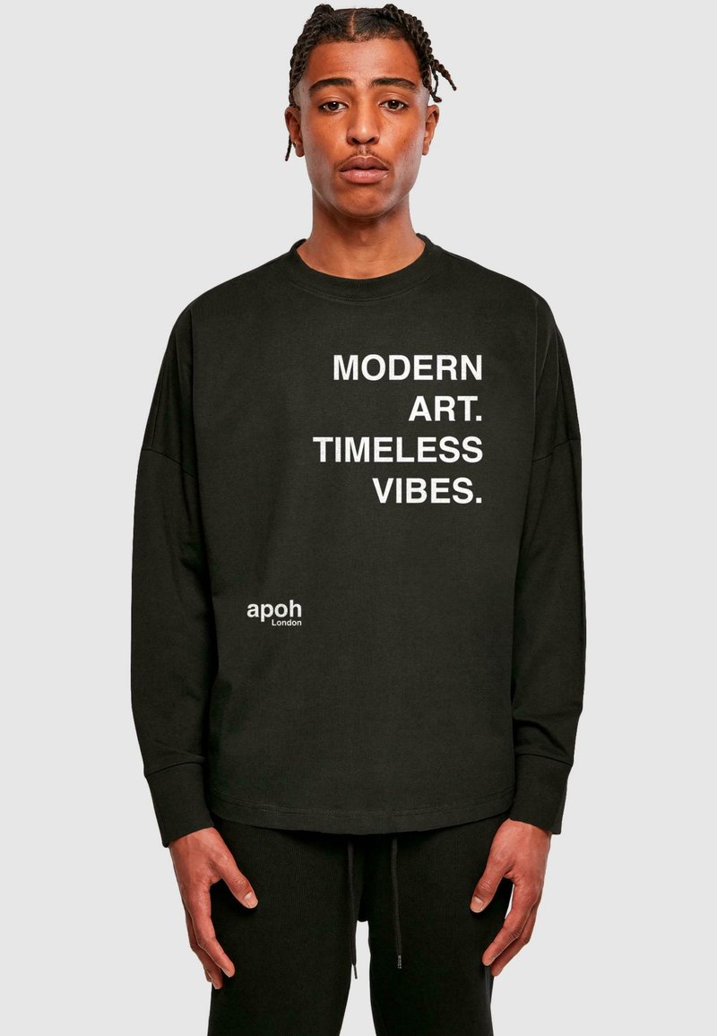 Schwarzes Langarm-T-Shirt mit kräftigem weißem Text: "MODERNE KUNST. Zeitlose Vibes." mit einem kleinen Logo unten links. Weicher Stoff.