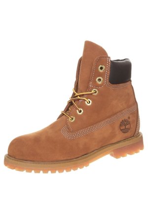 Brun læderarbejdsstøvle med snøre, polstret sort krave, robust sål, metalknaphuller og Timberland-logo på siden.