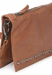 Bolso clutch de piel marrón con un acabado texturizado, tachuelas plateadas a lo largo del borde inferior y un cierre de cremallera en la parte superior. Cuenta con una correa desmontable.