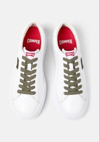 Valkoiset nahkakengät oliivinvihreillä nauhoilla, punaisilla sisäpohjilla ja pienellä logotarralla. Pyöreä kärkiosa ja kumipohja. Ylhäältä kuvattuna.