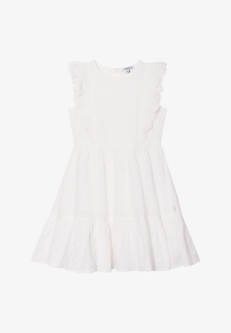 Vestido blanco sin mangas con una tela texturizada, que presenta acentos de hombros con volantes y un diseño de falda en capas. Cierre de botón en la parte trasera.