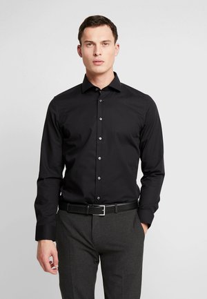 Black long-sleeve shirt with a pointed collar and a straight cut. Features silver buttons along the front. Smooth fabric texture.