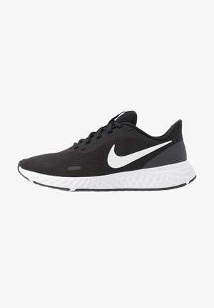 Chaussure de running Nike noire avec semelle blanche et logo swoosh blanc, tissu mesh respirant, design basse coupe et fermeture à lacets.
