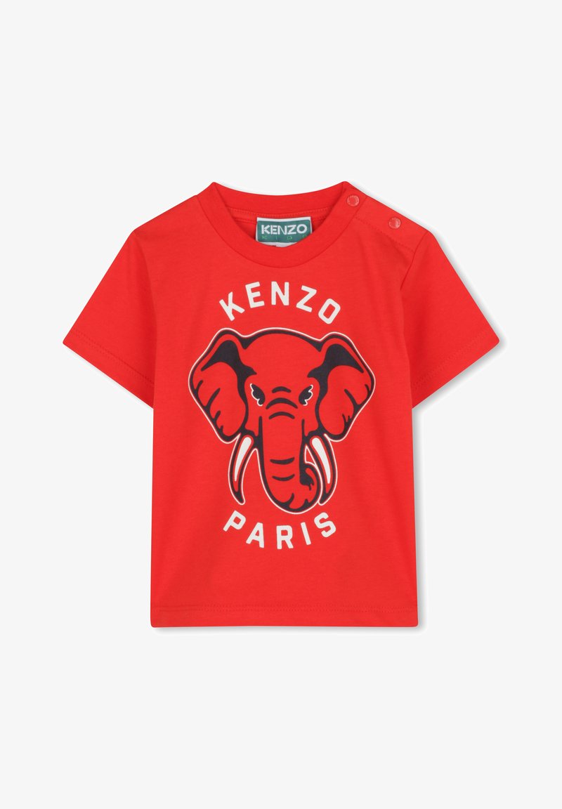 T-shirt en coton rouge avec un graphique d'éléphant aux contours noirs, texte "KENZO" et "PARIS" en dessous. Deux pressions sur l'épaule pour un habillage facile.