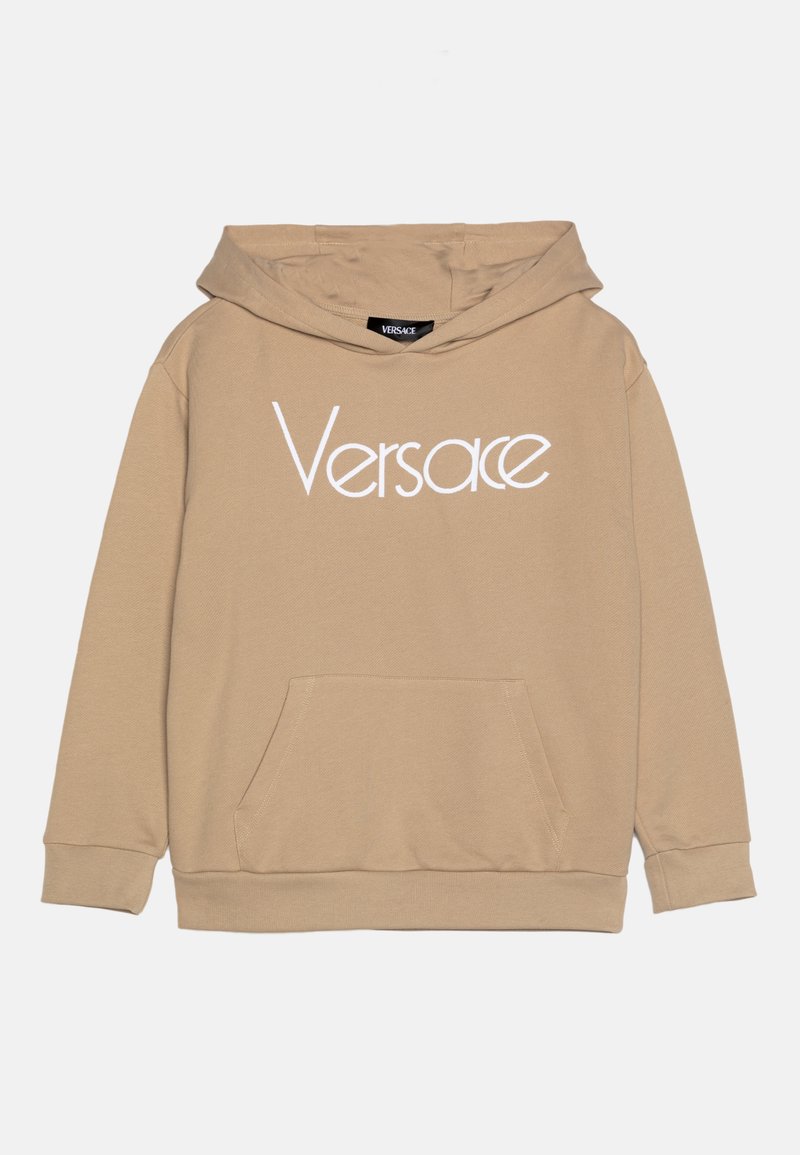 Beige huvtröja med framficka. Har en vit "Versace" logo över bröstet. Tillverkad av mjukt, texturerat tyg.