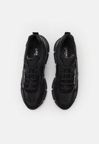 Svarta sneakers med en texturerad ovandel, med snörning och dragkedja. Tjock gummi sula och diskret logotyp på sidan. Tillverkad i Italien.