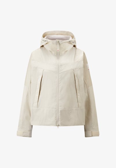 Beige leichte Jacke mit Kapuze, Frontreißverschluss und zwei großen Seitentaschen. Verfügt über schräge Nähte und eine leicht matte Textur.