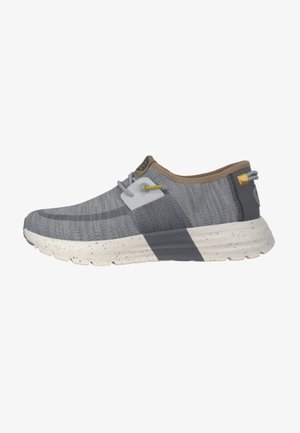 Scarpa sportiva grigia con tomaia in mesh traspirante, dettagli marroni, suola intermedia maculata in bianco e nero e design della suola flessibile.