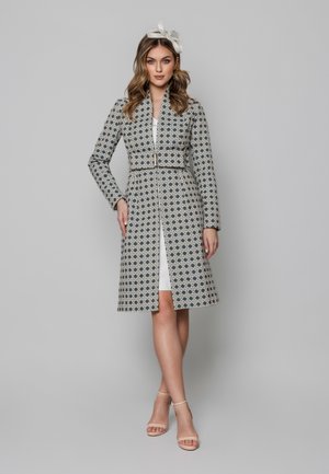 Navy i kremowy płaszcz w wzory, z kołnierzykiem, paskiem w talii i długością do pół łydki oraz długimi rękawami.