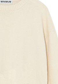 Beige kötött pulóver bordás kerek nyakkal és ejtett vállvarrással. Puha textúra és letisztult dizájn minta vagy díszítés nélkül.