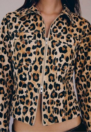 Džínová bunda s leopardím potiskem, která má zipové zapínání, límec, dvě náprsní kapsy a výrazný střih. Texturovaná tkanina v živých barvách.