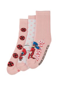 Tres pares de calcetines en rosa y blanco. Uno tiene un patrón de mariquitas rojas, otro presenta topos rosas y el tercero muestra un diseño de personaje.