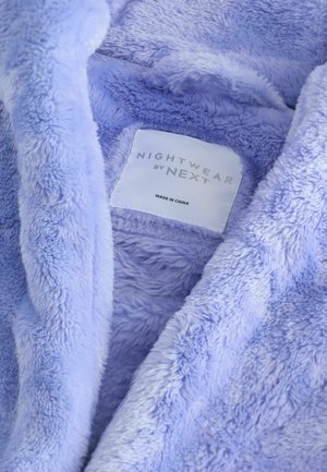 Pehmeä laventelinvärinen yöasu, jossa on rakenteellinen, pörröinen sisus. Tunnuslukuna on "NIGHTWEAR by NEXT" ja se ilmoittaa "VALMISTETTU KIINASSA."