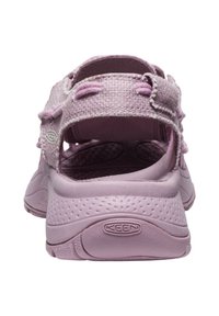 Sandalias Keen en rosa claro, con parte superior texturizada, diseño con cortes y suela de goma moldeada con logo en relieve. Estilo de espalda abierta.