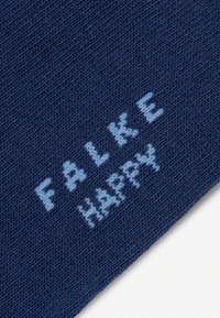 Σκούρο μπλε πλεκτό ύφασμα με τη φράση «FAKE HAPPY» υφαντή σε ανοιχτό μπλε νήμα διαγωνίως πάνω του.