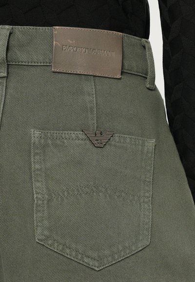 Pantaloni in cotone verde oliva con etichetta in pelle Emporio Armani in vita e piccolo logo metallico sulla tasca posteriore. Tessuto strutturato.
