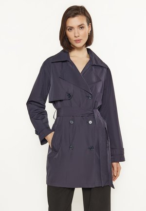 Námořnický modrý trench coat s dvouřadým zapínáním, velkým límcem, dvěma předními kapsami a páskem v pase. Hladká, lehká látka.