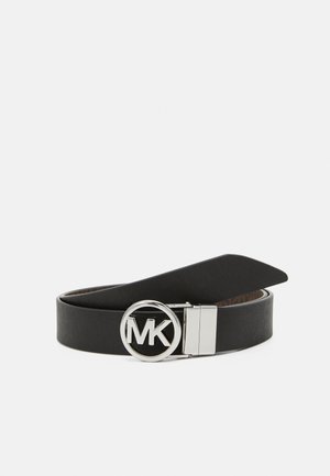 Zwarte leren riem opgerold met een zilveren ronde gesp met de initialen "MK" op een witte achtergrond.