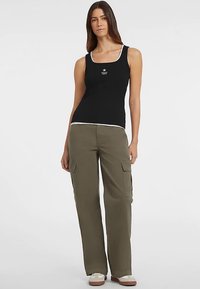 Czarny top na ramiączkach z białym obszyciem i małym logo w kształcie gwiazdki, zestawiony z oliwkowozielonymi spodniami cargo z bocznymi kieszeniami i luźnym krojem.