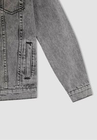 Szara kurtka jeansowa o klasycznym kroju, z dwoma kieszeniami, kontrastującym przeszyciem i fakturowanym wykończeniem. Proste rękawy i wykończony dół.