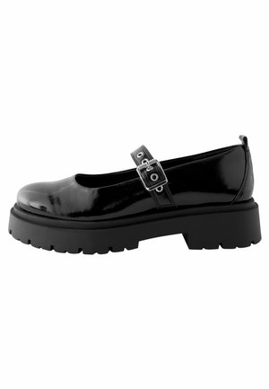 Chaussure Mary Jane en cuir verni noir avec semelle épaisse à crampons et bride réglable à boucle, vue de côté sur fond blanc.