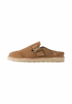 Brauner Wildleder-Slipper mit seitlichem Schnallenriemen und beige-gummisohle, entworfen für lässiges Tragen und angenehmes Hineinschlüpfen.
