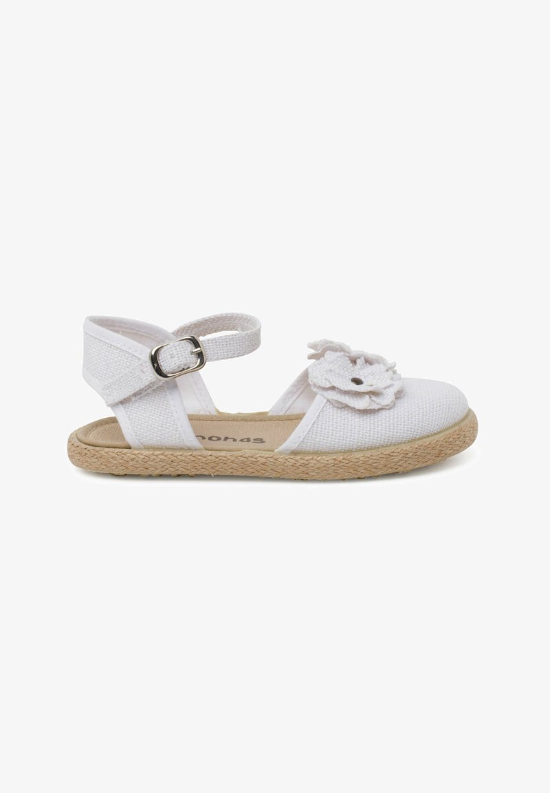 Sandale espadrille blanche avec une tige en tissu texturé, une lanière de cheville et un ornement floral décoratif au niveau des orteils. Semelle extérieure en jute.