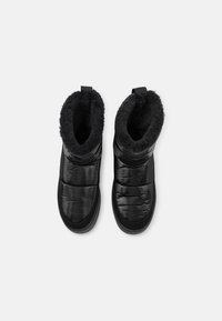 Svart isolerade stövlar med en kviltad utsida, mjukt foder i päls och justerbara remmar. Utformade med en rund tå och platt sula.