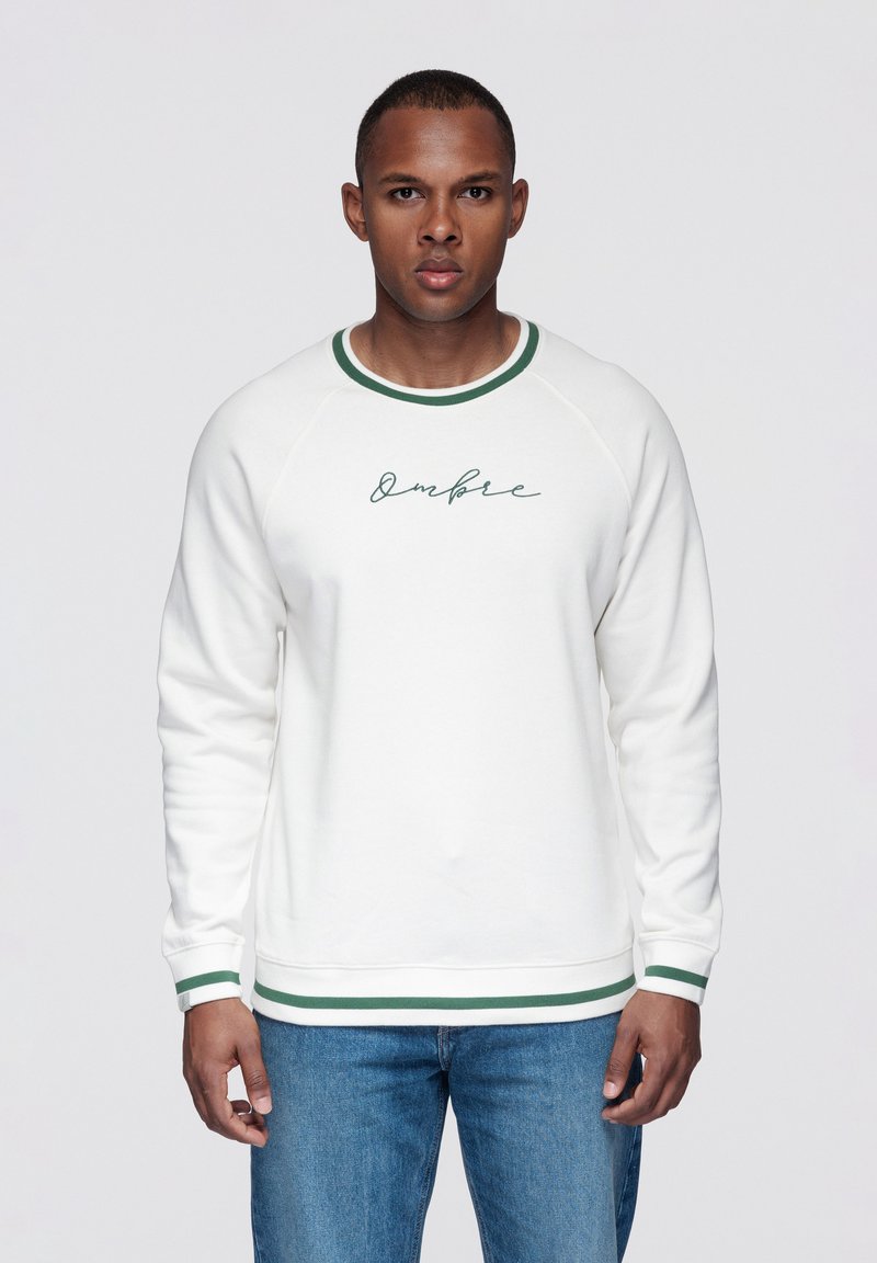 Vit sweatshirt med gröna detaljer och krage. Har en skriptlogga "Ombre" på bröstet samt ribbade muddar och fåll.