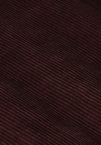 Bruine corduroy stof met een verticale ribbeltextuur, die een diepe tint en een zachte afwerking toont, geschikt voor kleding of bekledingstoepassingen.