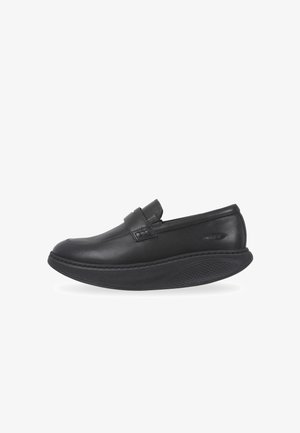 Zapato negro de piel tipo slip-on con punta redondeada, suela de goma texturizada y un acento cosido a lo largo del empeine. Acabado suave y perfil bajo.