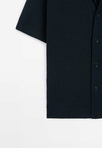 Dark navy short-sleeve cardigan made of textured knit fabric, featuring a V-neck, front buttons, and ribbed hem detailing.