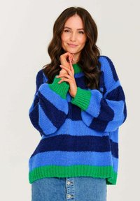 Pruhovaná svetřík v tmavě modré, světle modré a zelené barvě. Silná pletenina, oversized střih, široké rukávy a žebrovaný lem.