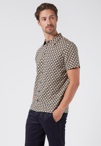 Korte mouwen overhemd met een geometrisch patroon in geel, blauw en zwart. Voorzien van een kraag en een knoopsluiting aan de voorkant, gemaakt van lichtgewicht stof.