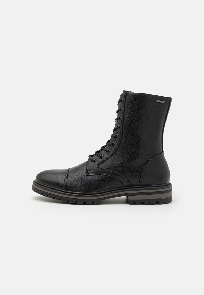 Botte de combat en cuir noir à lacets avec embout et semelle robuste, vue de côté sur fond blanc.
