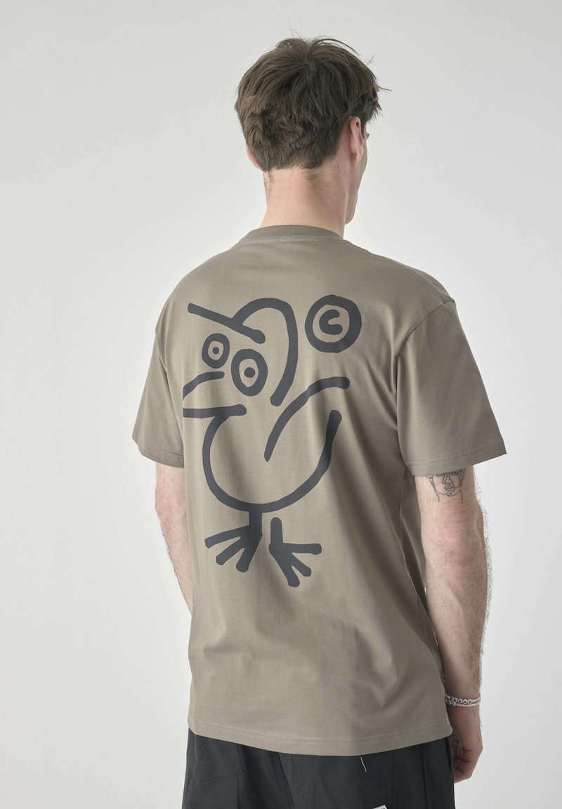 Olive green cotton t-shirt featuring a large black graphic of a bird on the back, short sleeves, and a standard fit.