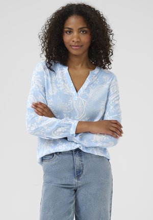 Light blue blouse with white floral paisley pattern, features a V-neckline, long sleeves with button accents, and a relaxed fit.