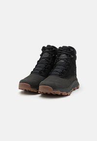 Czarne buty trekkingowe z teksturowanej zamszowej i syntetycznej cholewki, z wysoką cholewką, gumową podeszwą oraz wyraźnym wzorem przyczepności.