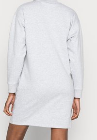 Heathergrå sweatshirtklänning med långa ärmar, rundad halsringning och en avslappnad passform, som visar en jämn, mjuk textur.