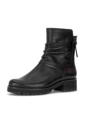 Bottine en cuir noir avec talon bas bloc, fermeture éclair arrière et design légèrement froncé autour de la cheville sur fond blanc.