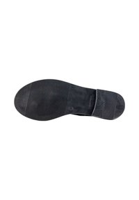 Suela de zapato negra con superficie de goma texturizada, que presenta ranuras horizontales y una sección de talón lisa. Se pueden ver marcas en la suela.