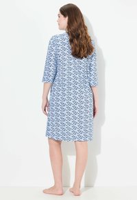 Abito blu a fantasia con maniche a tre quarti, caratterizzato da un motivo a onde in blu navy. Lunghezza al ginocchio con vestibilità comoda e texture liscia.