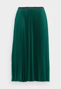 Vihreä pleated midi-hame, jossa on tekstuuri ja musta vyötärö, jossa on "Lacoste"-logo. Hameessa on virtaava, rakenteellinen muotoilu.