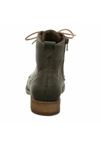 Botte de cheville en cuir marron, avec un bout arrondi, des coutures contrastantes, une fermeture éclair sur le côté et un talon empilé. Présente des lacets au niveau du col.