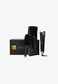 Zestaw prezentowy GHD platinum+ zawiera czarną prostownicę, szczotkę paddle z teksturowanym uchwytem oraz eleganckie etui w czarnym krokodylim wzorze.