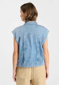 Lichtblauwe denim vest met korte mouwen, een kraag en een achtersteuvel. Heeft een rechte snit met zichtbare naden en een licht vervaagde textuur.