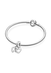 Bracciale in argento con un design rotondo e liscio, dotato di una perlina centrale incisa con lettere e due ciondoli a forma di cuore con la scritta "Sorella."